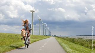 Fahrradfahrerin vor Windpark